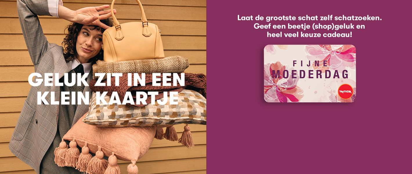 Glimlachende vrouw die een handtas in evenwicht houdt op dekens en kussens. Met de kop ‘GELUK ZIT IN EEN KLEIN KAARTJE’ en de CTA ‘CADEAUKAART KOPEN’.